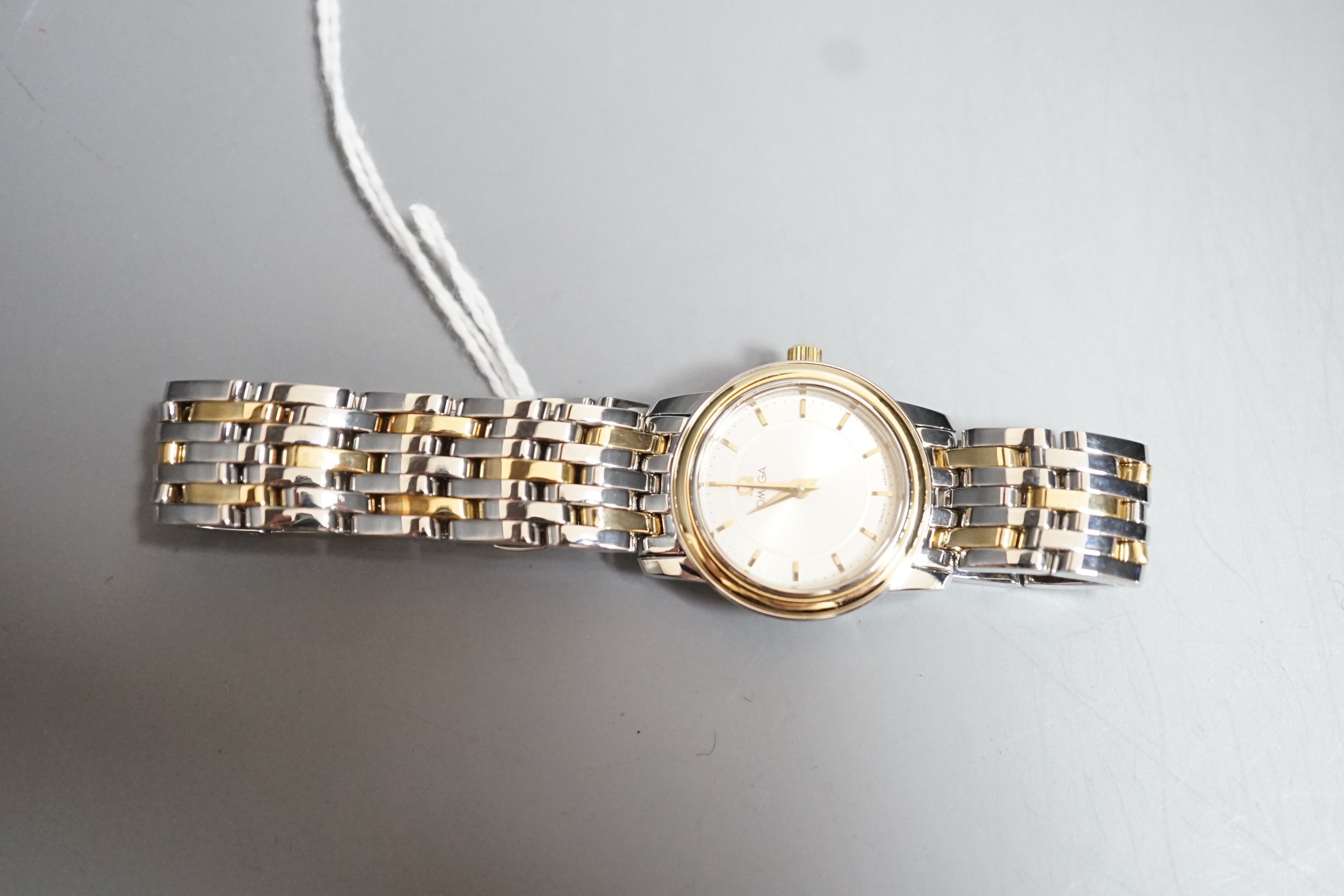 A lady's steel and gold plated Omega quartz wrist watch, on steel and gold plated Omega bracelet, with Omega carrying case.